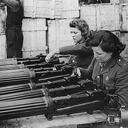 Water-cooled machine guns just arrived from the USA under lend-lease are checked at an ordnance depot in England