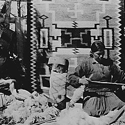 Spinning wool into yarn to be used in Navajo rug weaving. Southern Navajo Agency