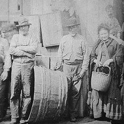 Bearded Irish clam diggers and a matronly companion on a wharf in Boston