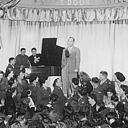 Bing Crosby, stage, screen and radio star, sings to Allied troops at the opening of the London stage door canteen in Piccadilly, London, England.