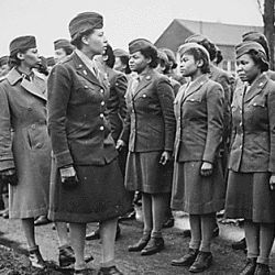 "Somewhere in England, Maj. Charity E. Adams,...and Capt. Abbie N. Campbell,...inspect the first contingent of Negro members of the Women