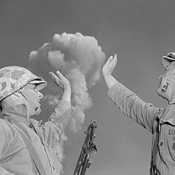 The atomic cloud formed by the detonation seems close enough to touch, and tension gone, Poth and Wilson do a little clowning for the camera