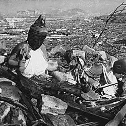 Battered religious figures stand watch on a hill above a tattered valley. Nagasaki, Japan.
