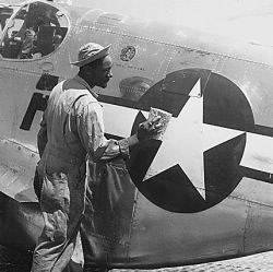 "Staff Sgt. William Accoo..., crew chief in a Negro group of the 15th U.S. Air Force, washes down the P-51 Mustang fighter plane of his pilot with soap and water before waxing it to give it more speed