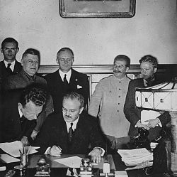 Soviet Foreign Minister Molotov signs the German-Soviet non-aggression pact; Joachim von Ribbentrop and Josef Stalin stand behind him, Moscow, August 23. 1939. Von Ribbentrop Collection