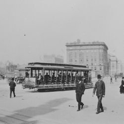 The Eighth Avenue trolley, New York City, sharing the street with horse-drawn produce wagon and an open automobile. Downtown, looking north