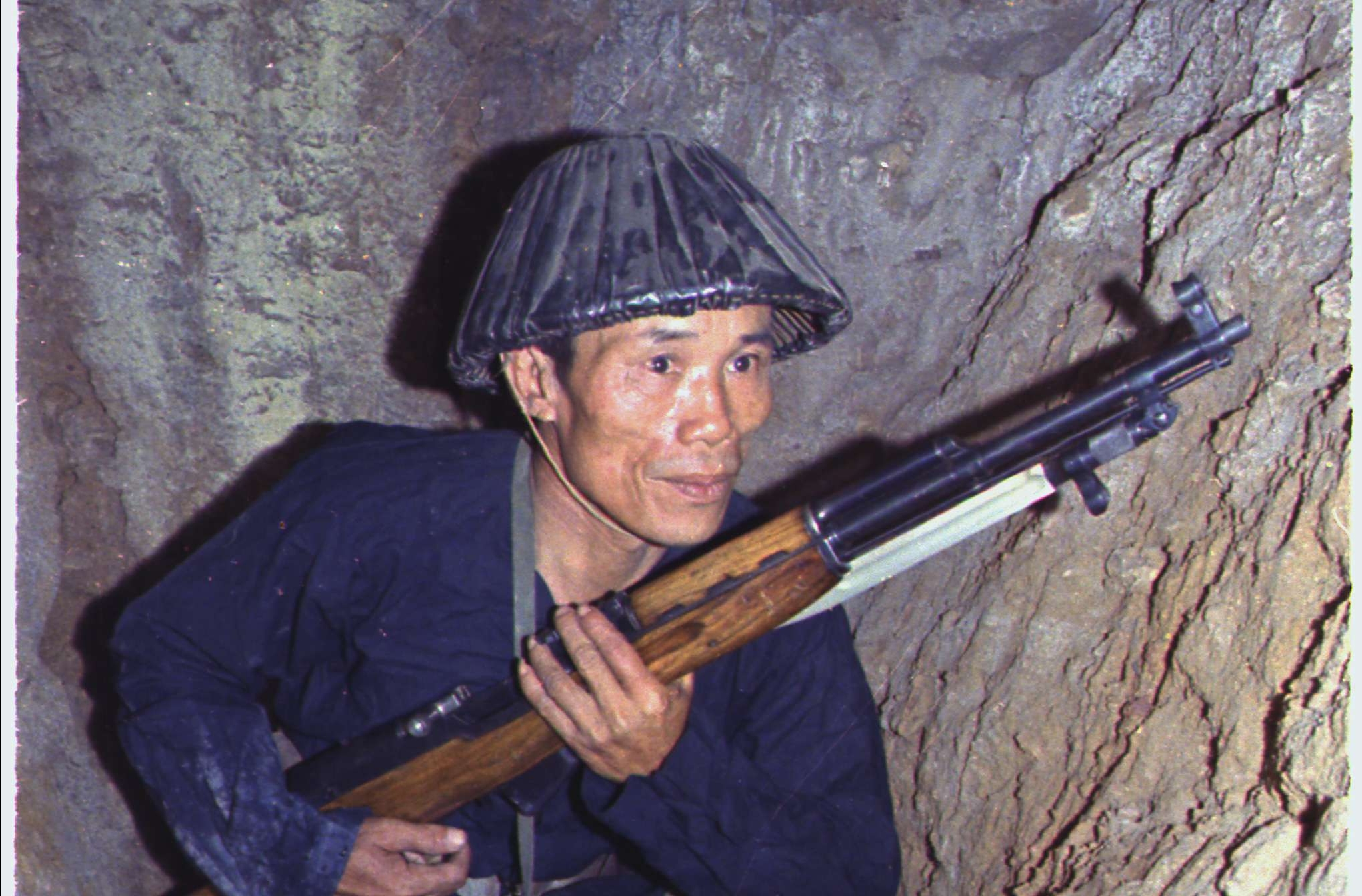 A Viet Cong Soldier Crouches in a Bunker with an SKS Rifle