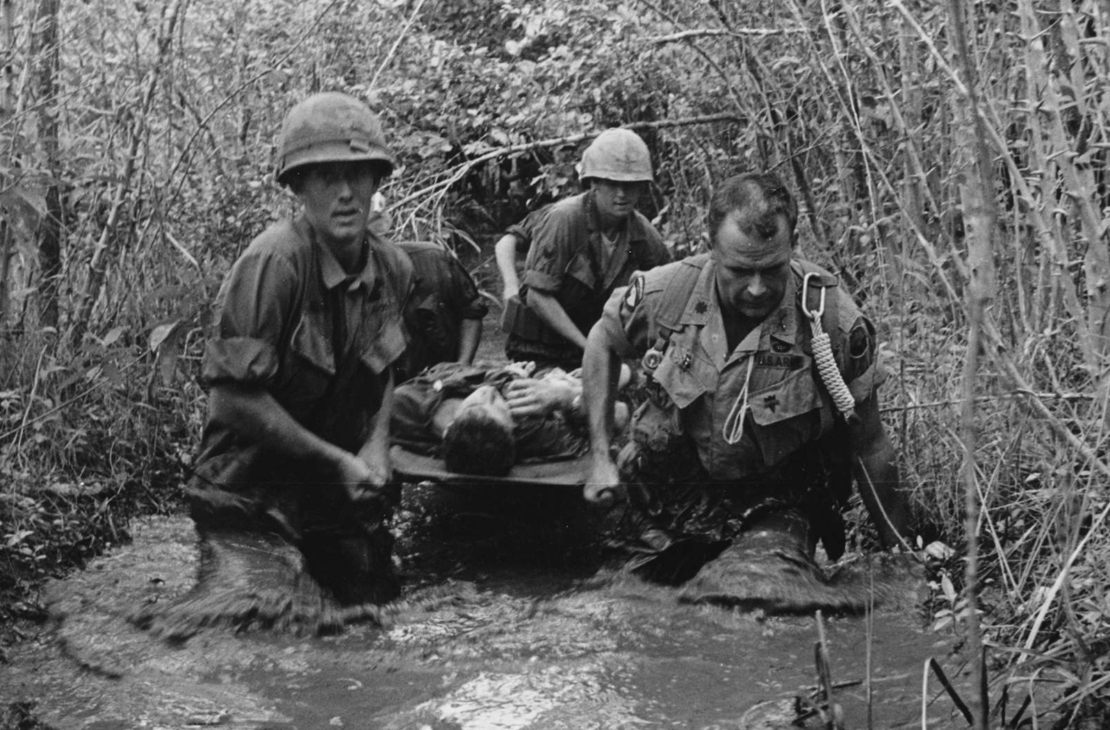 Soldiers Carry a Wounded Comrade Through a Swamp